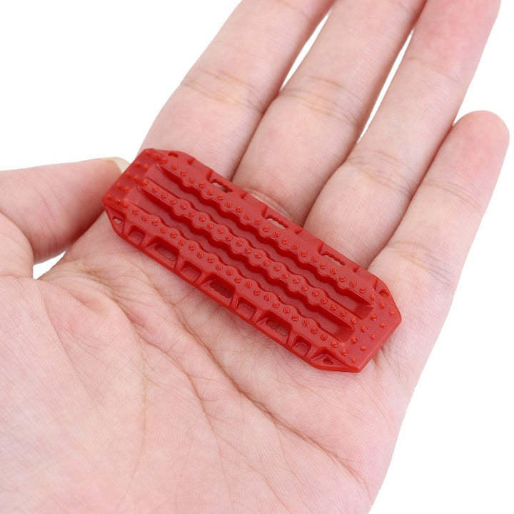 a Red Plastic Sand Ladder Board on a hand
