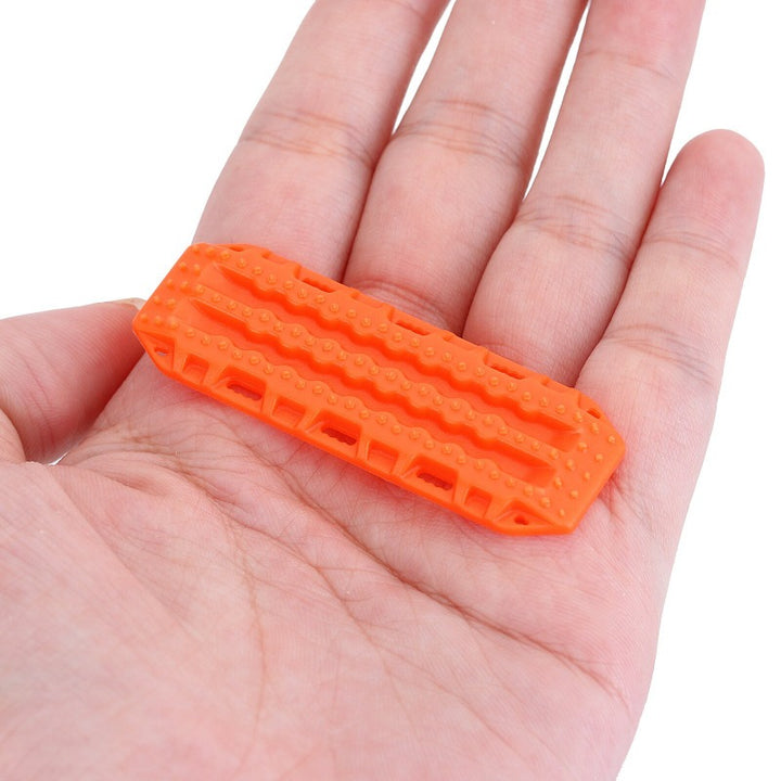 a Mini Orange Plastic Sand Ladder Board on a hand